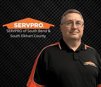 man with glasses smiling at the camera with servpro logo and franchise info